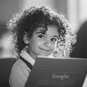 Fillete qui tient une carte du restaurant Famiglia